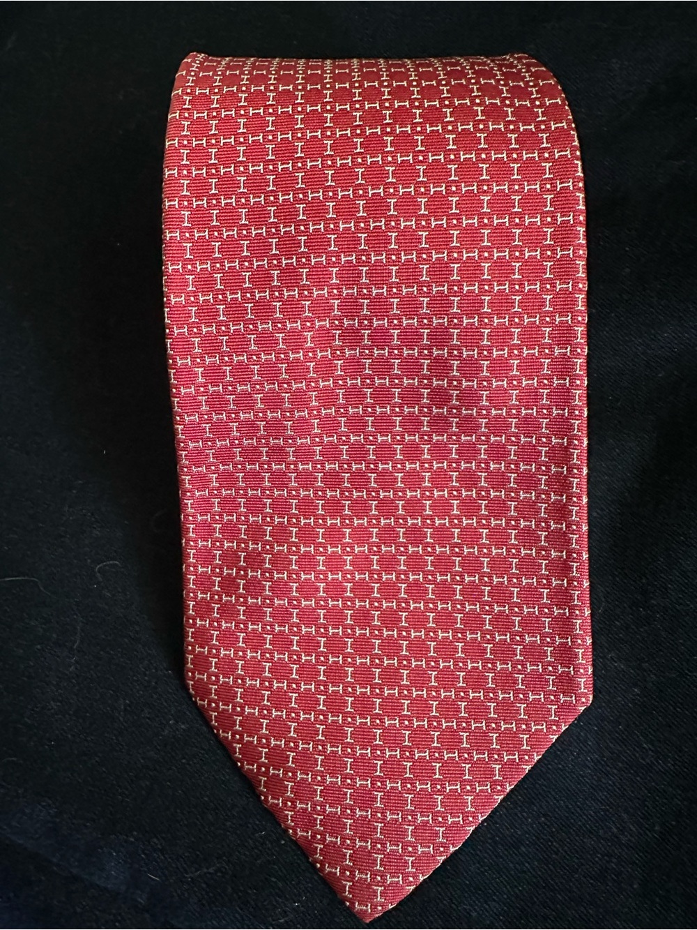 Hermes tie in brick-red offset by delicate cream thread accents. 100% silk